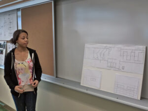 A student presenting charts to her class