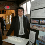 Male architecture student with a model of a small building